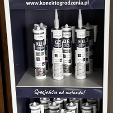 Kostka brukowa i kamień ozdobny - Regał z klejami montażowymi, z etykietami opisującymi produkt i zastosowanie. Nad półkami widnieje napis "Specjaliści od melanżu!".