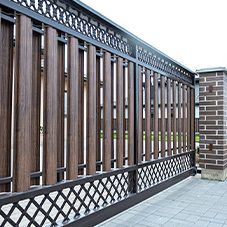 Kostka brukowa i kamień ozdobny - Nowoczesna brama przesuwna, łącząca metalowe elementy z pionowymi panelami w kolorze drewna. Prowadzi do podjazdu z jasnej kostki brukowej.